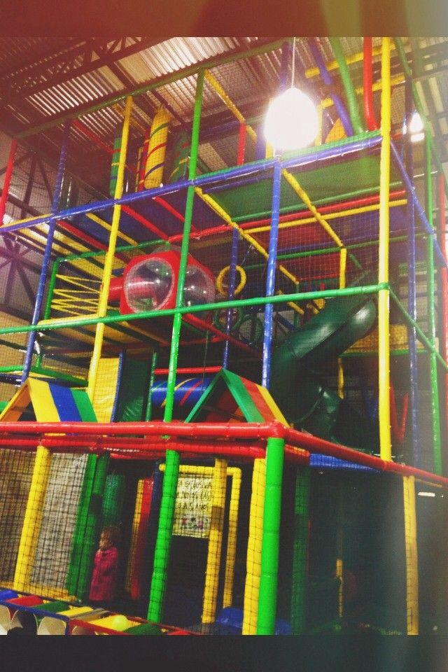 A colorful indoor playground with tubes, slides, and climbing structures.