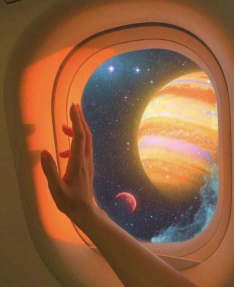 A view of planets and stars through an airplane-style window.